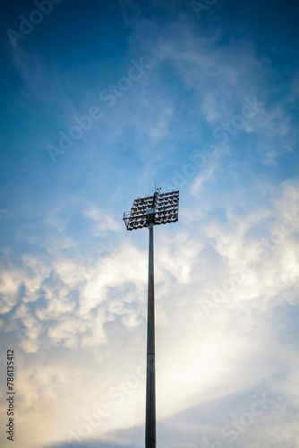 Stadium lights isolated on blue sky and clouds.