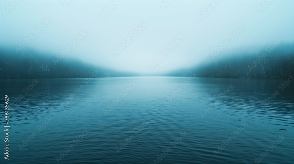 A shroud of mist hangs over a tranquil lake,