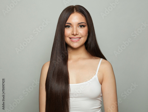 Cute young woman brunette with long healthy hair and fresh silky skin posing on white background. Fashion beauty studio portrait © artmim