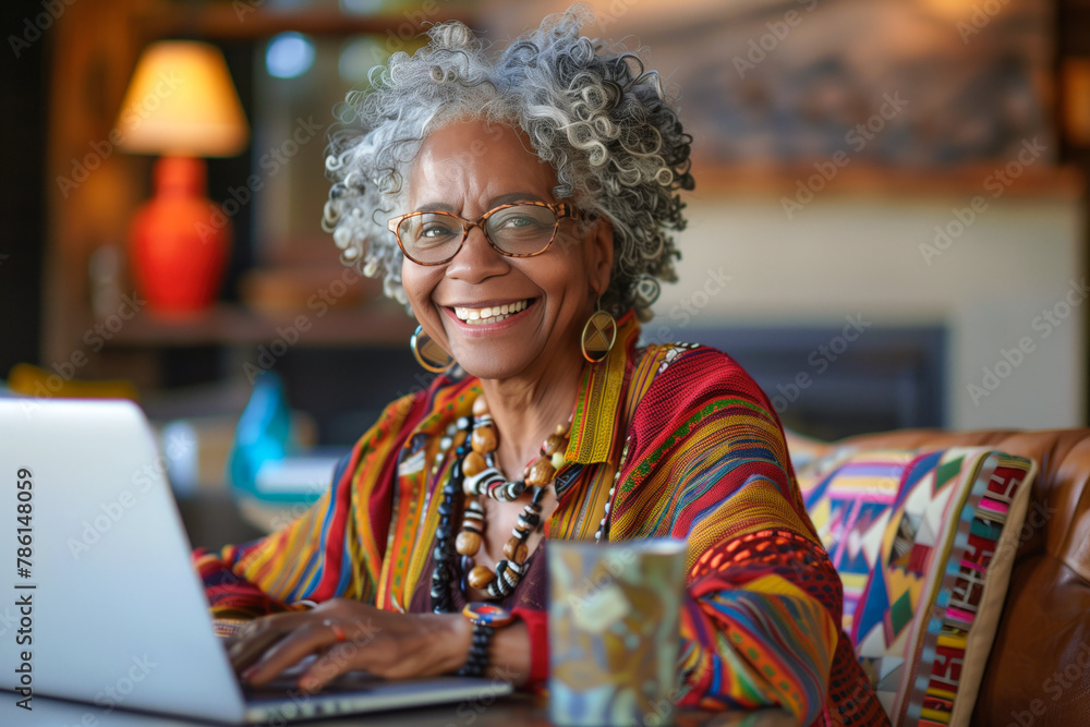 Joyful senior lady using laptop at home