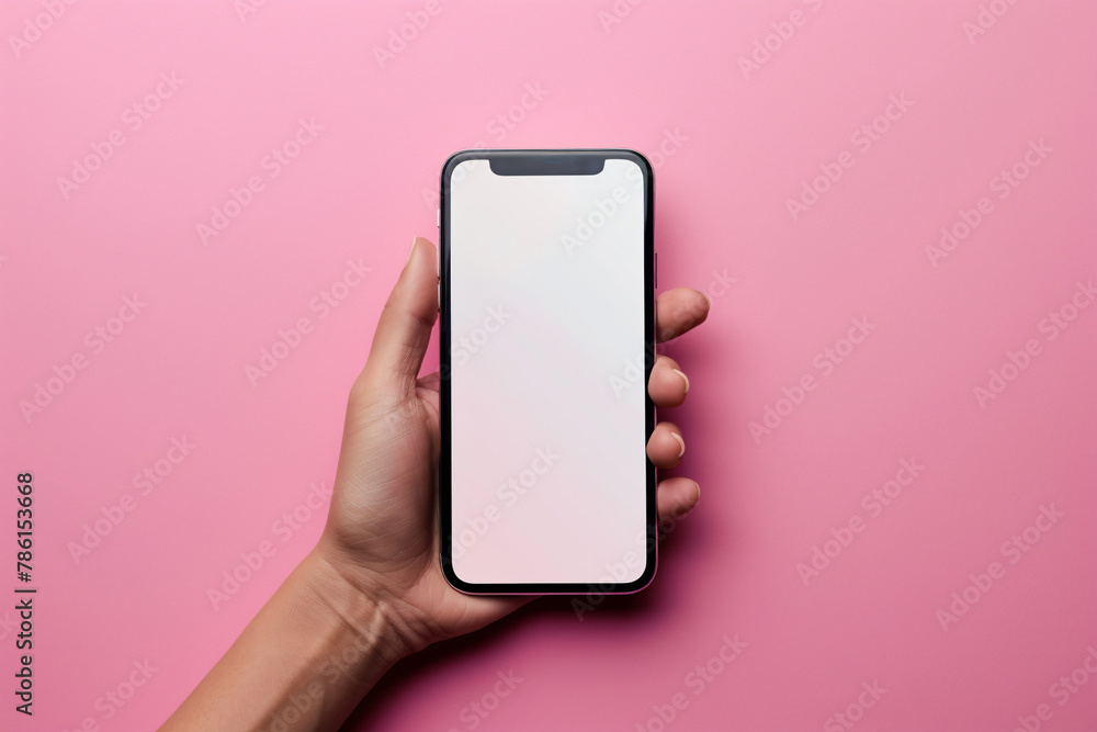 Woman's hand holding mobile phone with white empty screen in front of pink background with copy space. - obrazy, fototapety, plakaty 