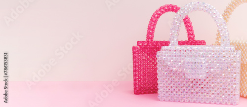 Banner with handcraft bags made from beads in front of beige and pink background.