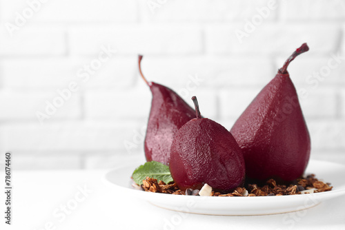 Tasty red wine poached pears with muesli on white table, closeup. Space for text