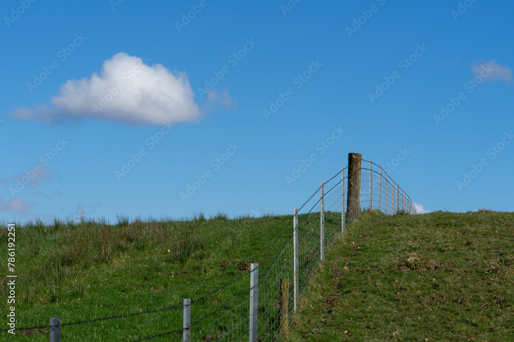 Wire fence over the brow of a hill