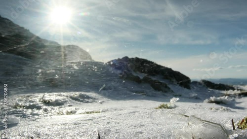 Hiker walking up snowy mountain with wind blowing snow - Ben Resipol - Scotland photo