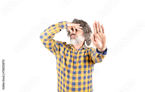 Bearded man in checkered shirt smelling something smelly and disgusting holding his breath with fingers in his nose, bad smell