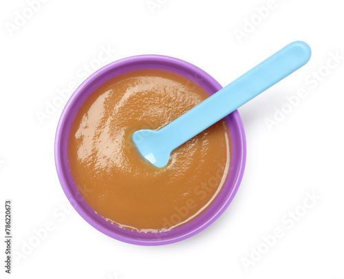 Delicious baby food and spoon in bowl isolated on white, top view