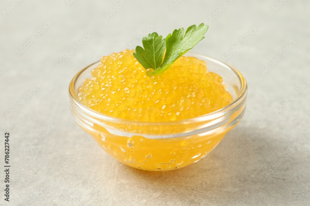 Fresh pike caviar in bowl and parsley on light grey table Fresh pike caviar in bowl and parsley on light grey table