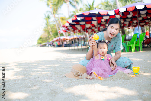 Mother and girl playing in the sand on the beach, Pattaya, Thailand,Mother with children playing with sand on beach 