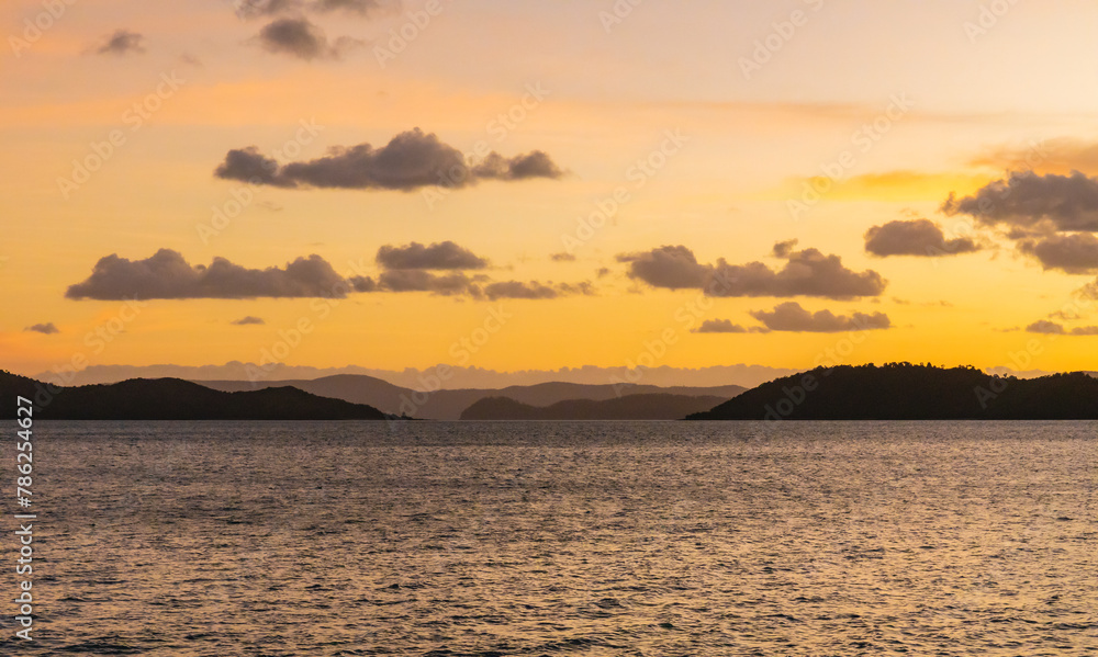 Sunset on the water with island hills on the horizon