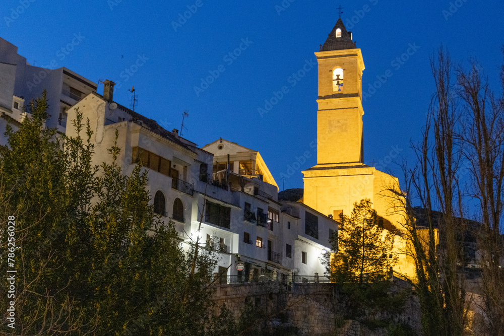 Alcalá del Júcar at night, located on a rock formed by the gorge of the Júcar River, cave houses roman bridge, castle, Church of San Andrés Apóstol (Albacete, Spain).