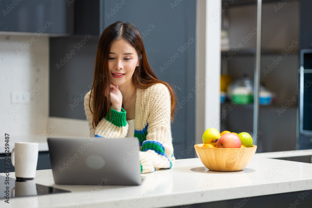 Happy woman relaxing at home - young Asian woman Relaxed working with computer at home. remote working from home office during quarantine Happy woman relaxing at home - young Asian woman Relaxed working with computer at home. remote working from home office during quarantine