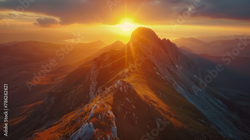 A majestic aerial view of a remote mountain range during golden sunset, highlighting the beauty of nature's wilderness.