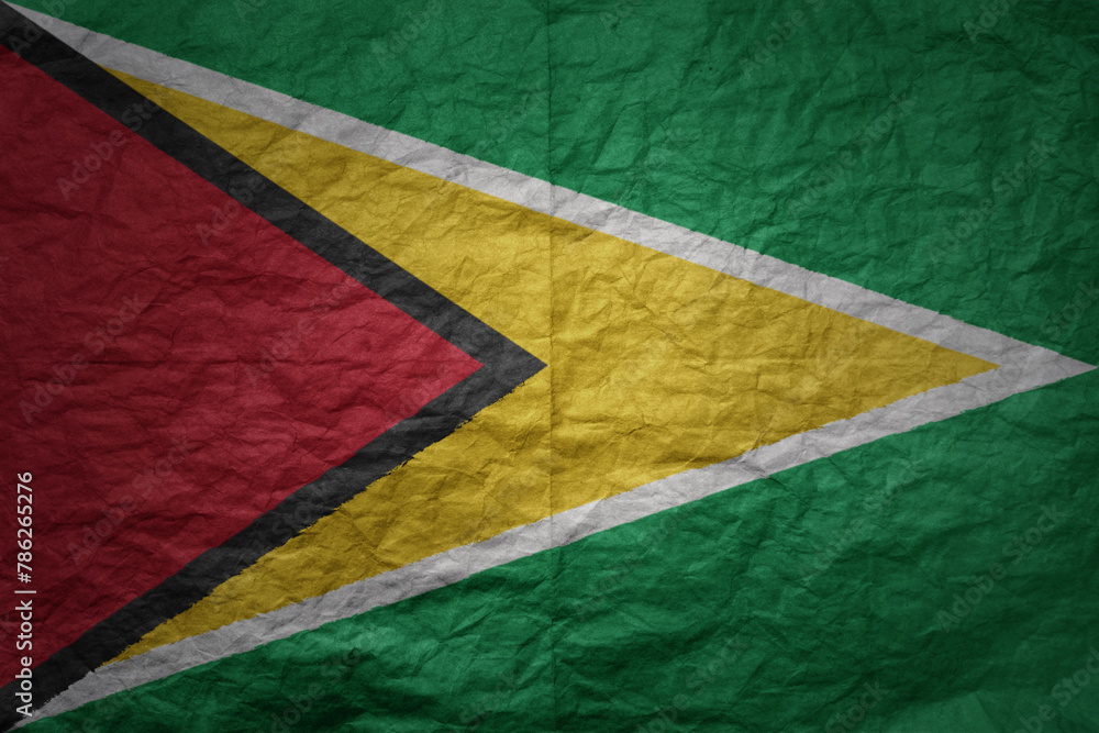 big national flag of guyana on a grunge old paper texture background
