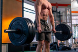 close up in a sports club a bald trainer in sports shorts lifts weights on a barbell