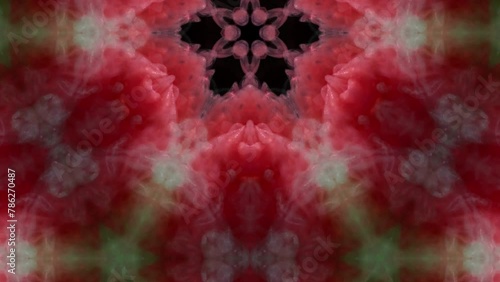 Breathtaking dance of red and green ink as it unfolds underwater, creating a stunning, symmetrical pattern reminiscent of a blooming flower.