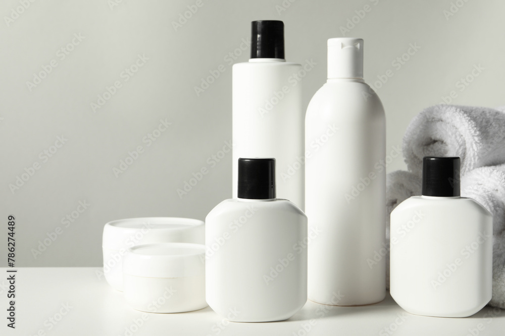 Different bath accessories on white table against grey background, closeup Different bath accessories on white table against grey background, closeup