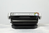 Electric grill on textured table against grey background. Cooking appliance