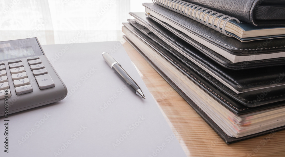 office table with notepad, blank paper , pen, calculator , notebooks and folders office table with notepad, blank paper , pen, calculator , notebooks and folders