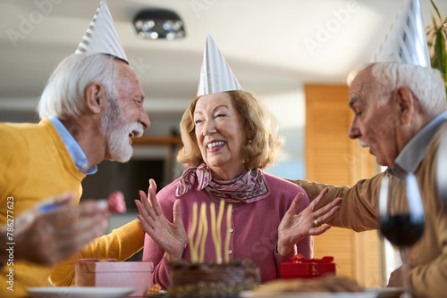Group of cheerful mature  friends having fun while celebrating Birthday at home.	