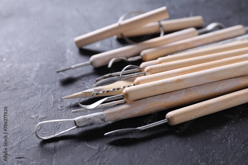 Fototapeta premium Set of different clay crafting tools on black table, closeup