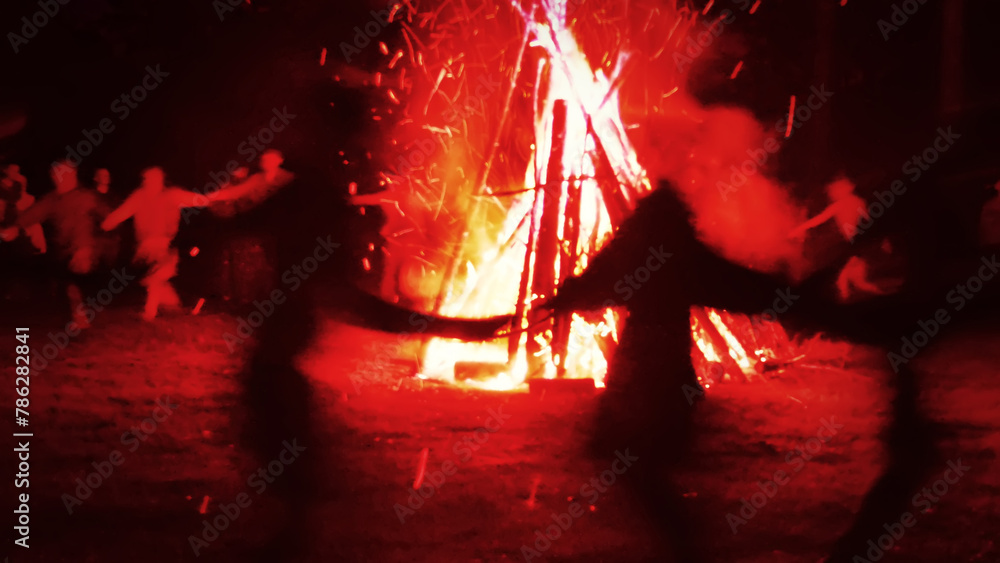 Huge fire at night and young people around. Pagan festival of Walpurgis ...