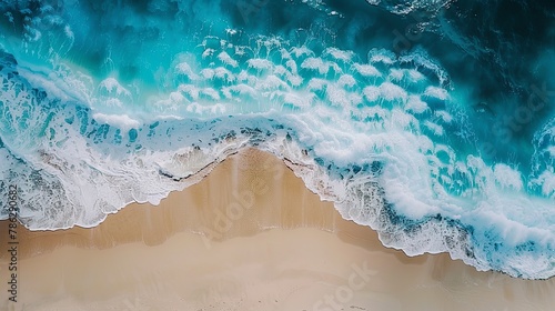 Electric blue wind waves create a mesmerizing pattern on the sandy beach © Mari