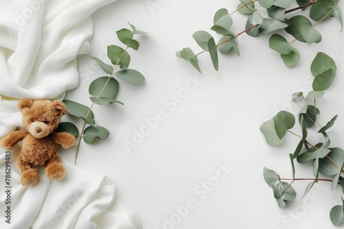 Baby onesie mockup with cute teddy bear and eucalyptus branch on cozy ivory blanket background photo