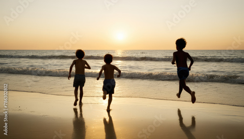 children running toward the water at a beach at dusk