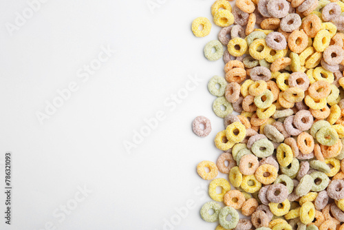 Tasty cereal rings on white background, flat lay. Space for text