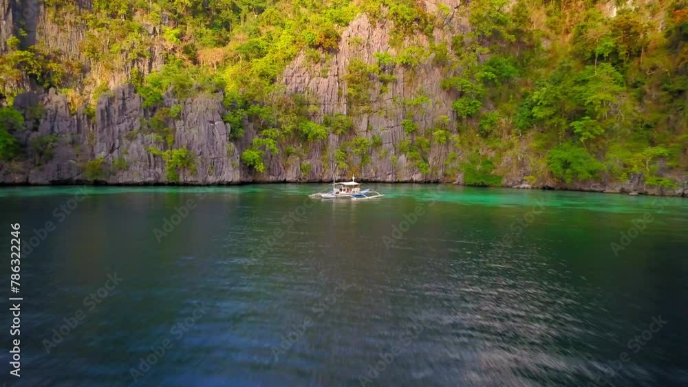 Aerial: Drone Forward Shot Of Outrigger Floating By Green Rock Formations - Palawan, Philippines