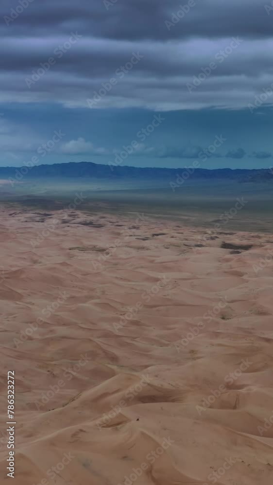 Aerial view on sand dunes with storm clouds at sunset in Gobi Desert, Mongolia. Vertical video Aerial view on sand dunes with storm clouds at sunset in Gobi Desert, Mongolia. Vertical video
