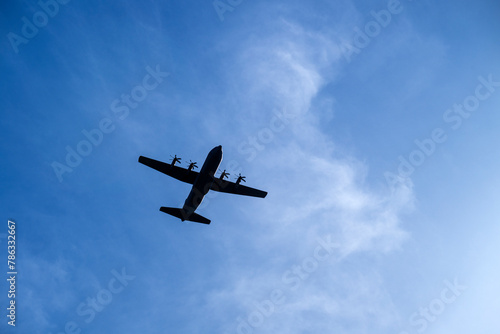 A military airplane silhouette on a blue sky