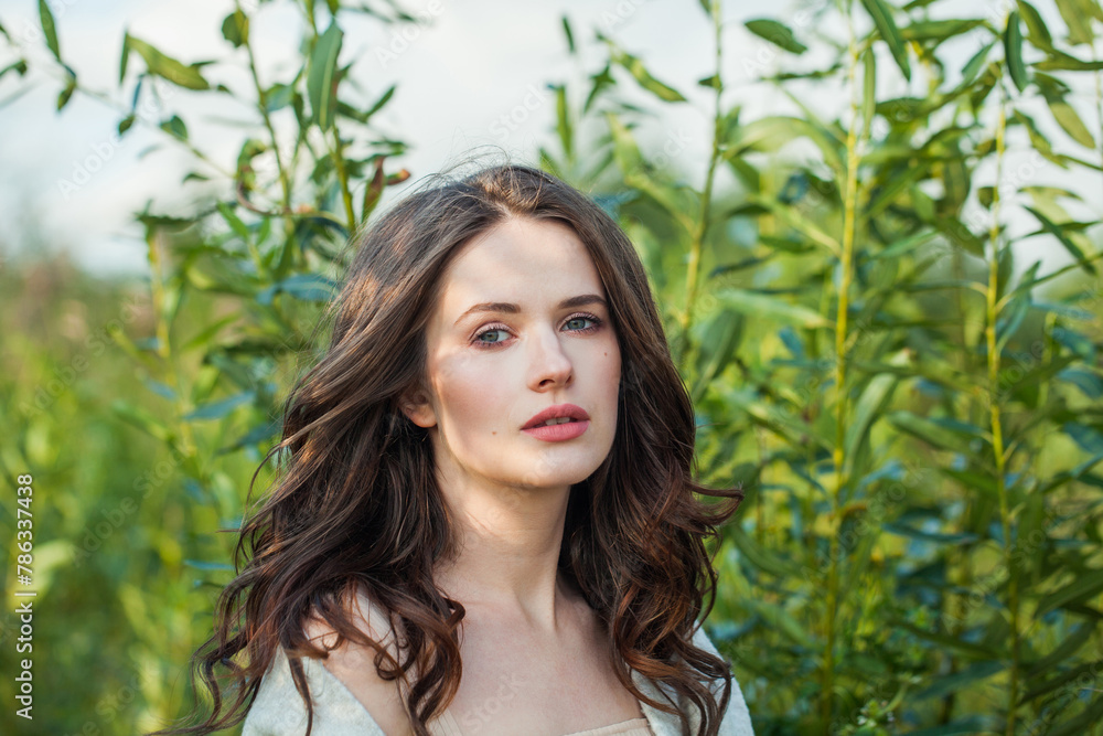Cheerful healthy young brunette woman with fresh clear skin and long dark brown hair outdoors on green grass background, air portrait Cheerful healthy young brunette woman with fresh clear skin and long dark brown hair outdoors on green grass background, air portrait
