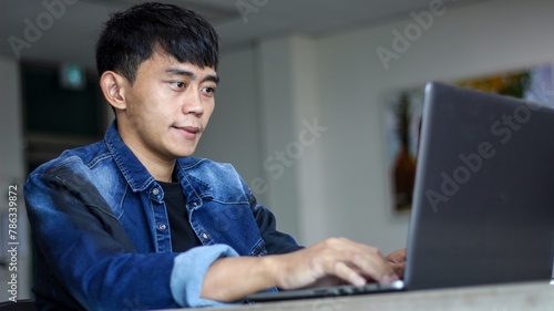Young man using laptop and smiling