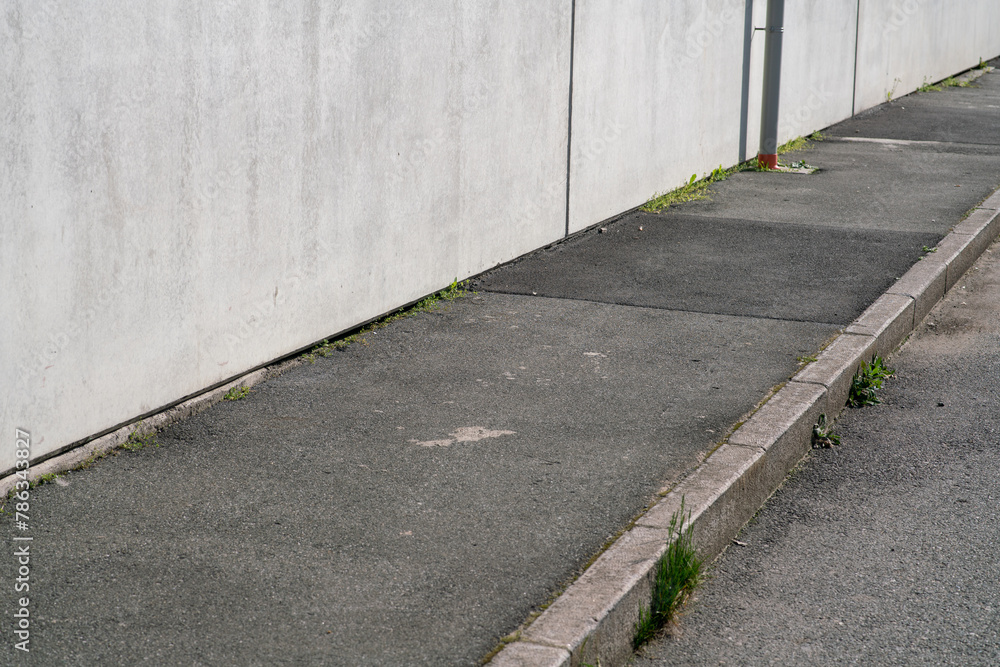 Obraz premium empty sidewalk, in an industrial area, urban elements in perspective without people.