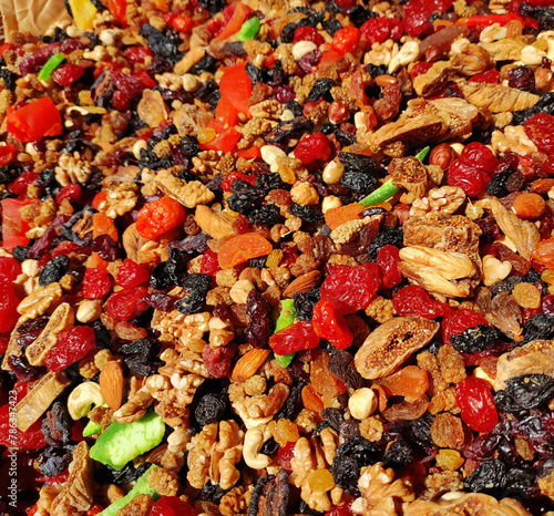 A mixture of colorful dried walnuts, cashews, hazelnuts and fruits, cherries, grapes, figs and kiwi
