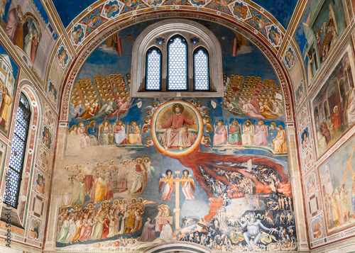 View of religious fresco in ruins decorating large wall inside medieval catholic church in Italy