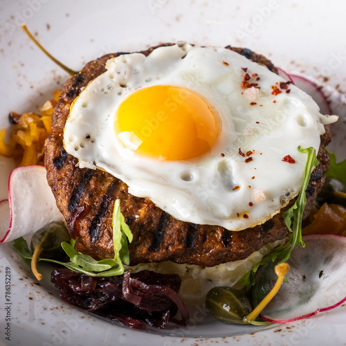 Beef steak with fried egg and mushed potato.	