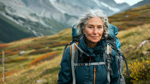 Mature hiker with backpack in alpine scenery. © Elena