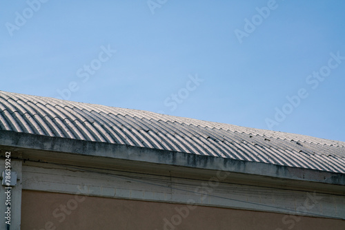 curved industrial roof with asbestos cement corrugations. Asbestos fibers are very dangerous when cut or broken, they cause lung cancer.