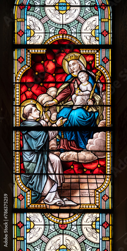 Saint Dominic receiving the rosary from the Virgin Mary. A stained-glass window in Église de la Sainte-Trinité (Holy Trinity Church) in Walferdange.