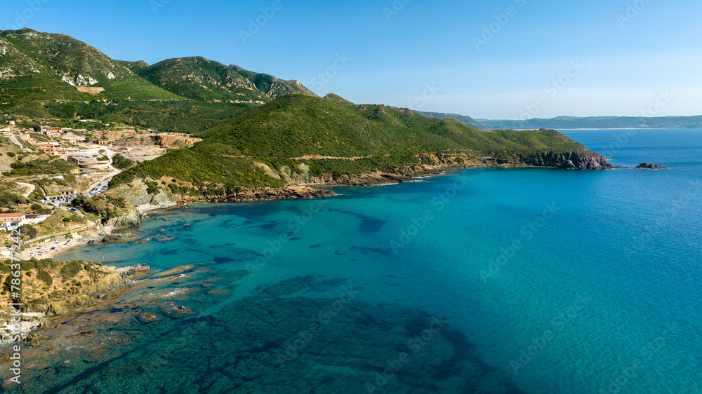 Aerial view of Masua beach near Porto Flavia in southern Sardinia, Italy. The sea is crystal clear, clean and with colors ranging from blue to turquoise. Aerial view of Masua beach near Porto Flavia in southern Sardinia, Italy. The sea is crystal clear, clean and with colors ranging from blue to turquoise.
