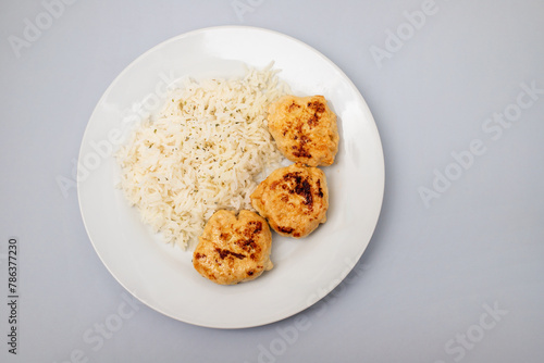 Fried chicken meatballs with boiled rice on plate