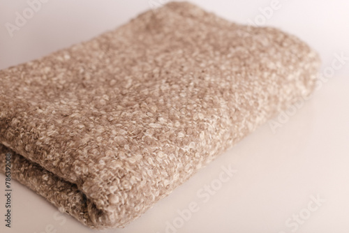 Cozy beige textured blanket, perfect for layering on a bed or sofa to create a warm and inviting atmosphere.