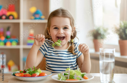 A cute little girl eating vegetables at the dining table, wearing colorful and holding cutlery in her hand