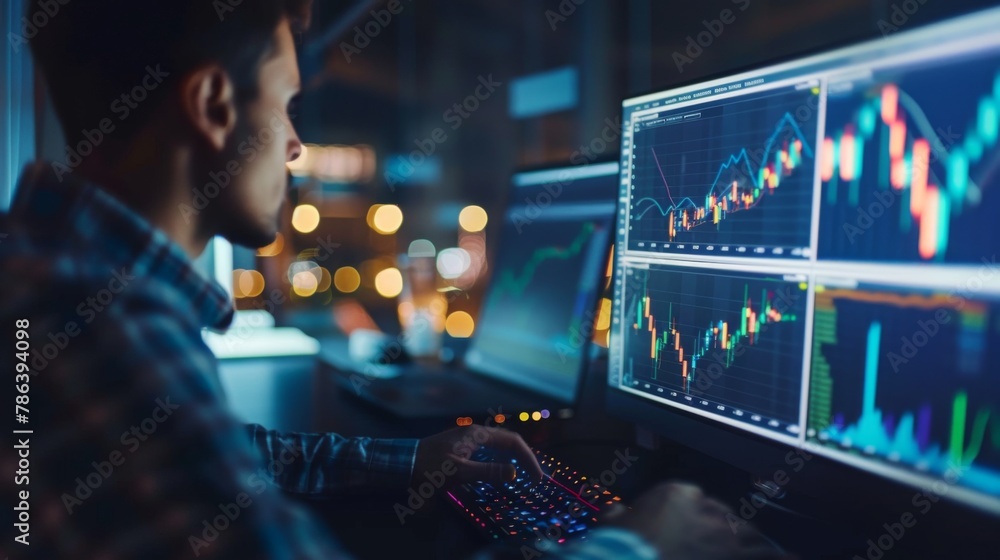 Trader Analyzing Financial Charts on Computer Screens at Night Trader Analyzing Financial Charts on Computer Screens at Night