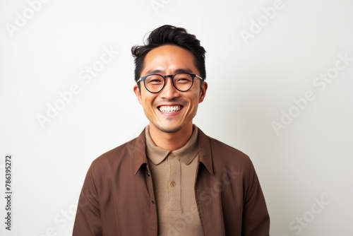 Portrait of a grinning asian man in his 30s wearing a chic cardigan on white background