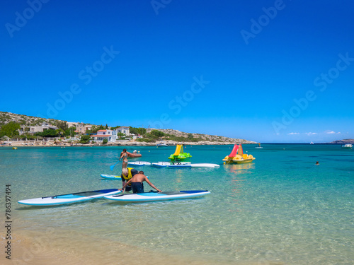 People enjoying water sports in a calm resort beach (Marathi Beach, Crete, Greece)