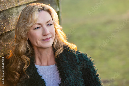 Attractive Thoughtful Middle Aged Woman Outside in Golden Sunshine